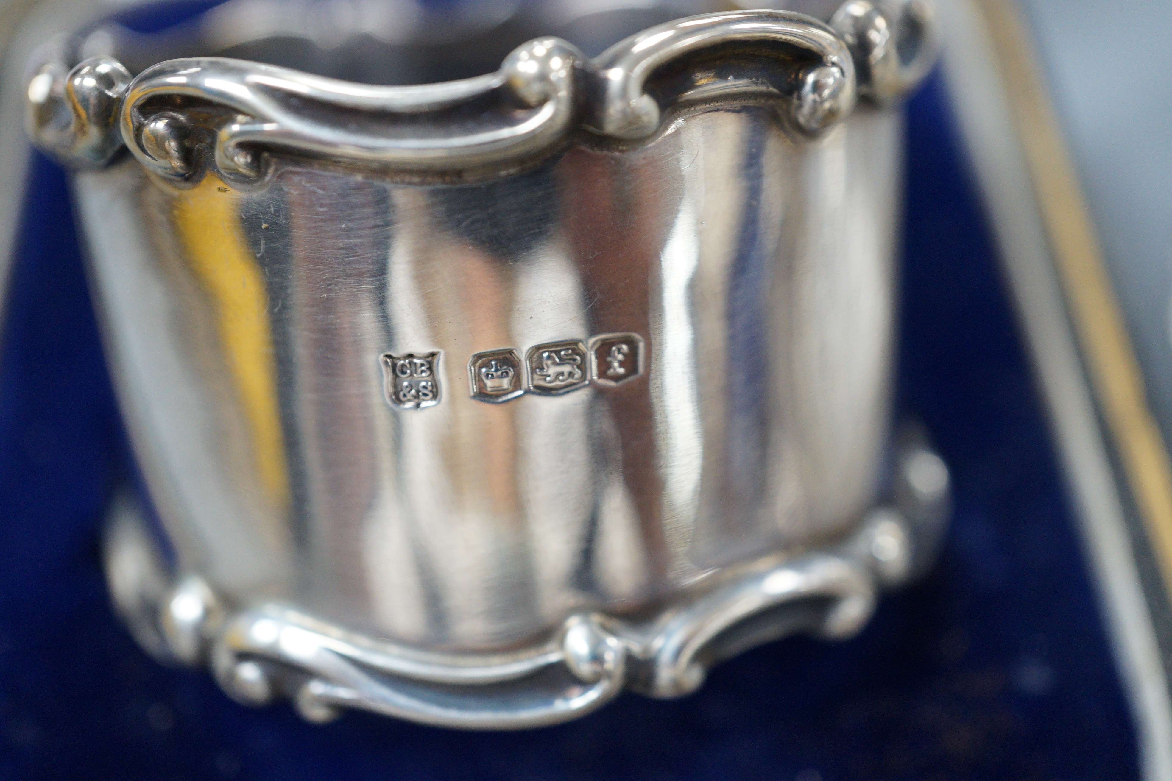 A collection of small silver items including napkin rings, repousse oval boxes, pair of bun salts, two ashtrays and a mounted table lighter, two modern wine labels, small box and three continental white metal items inclu